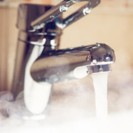 Mixer tap pouring steamy hot water