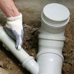 Plumber installing new PVC sewage drain pipes